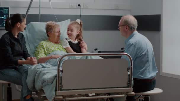 Çocuk, hastane koğuşundaki aile ziyaretinde hasta büyükanneye sarılıyor. — Stok video