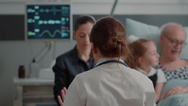 Zbliżenie lekarza pokazującego prześwietlenie córki pacjenta na oddziale szpitalnym — Wideo stockowe