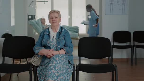 Портрет пожилого пациента, сидящего в зале ожидания — стоковое видео