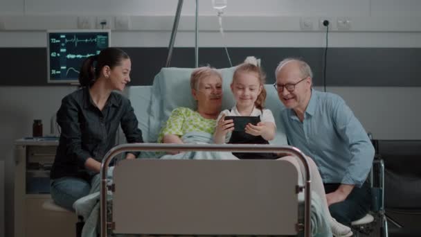 Child taking selfie with patient and family in visit using smartphone — 图库视频影像