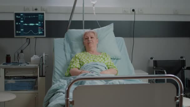 Портрет пожилого пациента лежащего на больничной койке — стоковое видео
