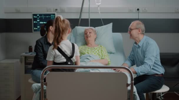Emerytowany pacjent rozmawiający z siostrzenicą podczas rodzinnej wizyty w szpitalu — Wideo stockowe