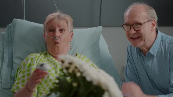 Close up de aposentado doente recebendo visita de filha e sobrinha — Vídeo de Stock
