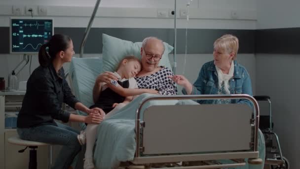 Niece αγκαλιάζει άρρωστος παππούς κατά την επίσκεψη στο κρεβάτι θάλαμο νοσοκομείο — Αρχείο Βίντεο