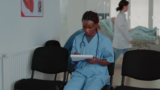 Κοντινό πλάνο του ιατρικού βοηθού που εξετάζει έγγραφα στην αίθουσα αναμονής — Αρχείο Βίντεο