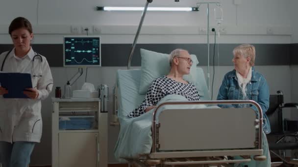 Hombre de edad disfrutando de la visita de hija y sobrina en la sala de hospital — Vídeo de stock