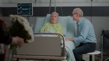 Family surprising retired patient with flowers and visit