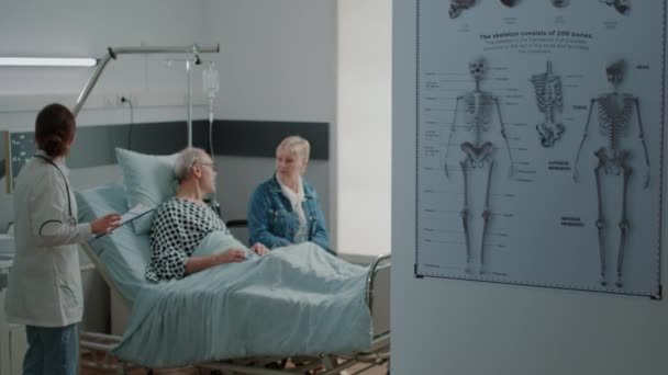 Madre y niña visitando al hombre mayor en la cama de la sala de hospital — Vídeos de Stock