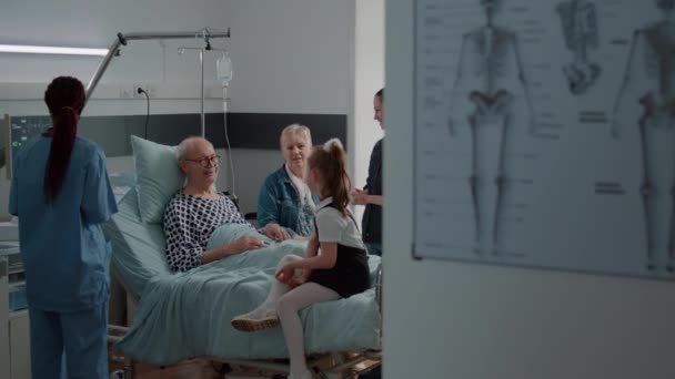 Hombre mayor disfrutando de chat con sobrina en visita en la cama de la sala de hospital — Vídeo de stock