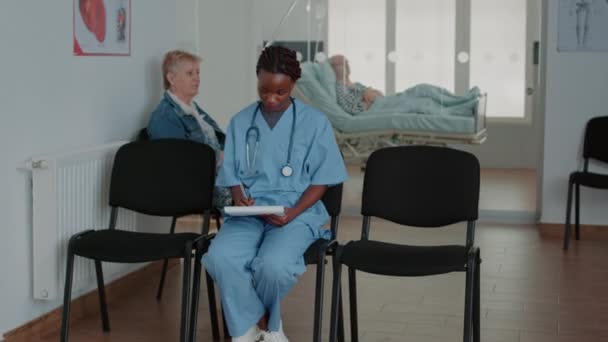 Retrato de enfermera afroamericana analizando papeles de chequeo — Vídeos de Stock