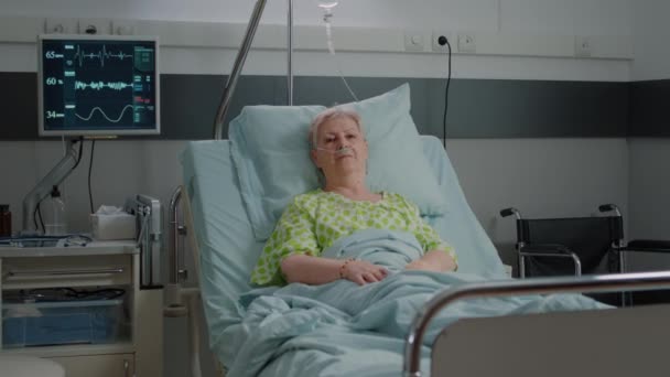 Portrait of pensioner waiting to receive medical support in hospital ward — Stockvideo