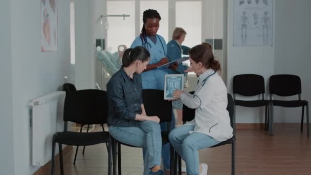 Team of nurse and doctor showing radiography on tablet — Wideo stockowe