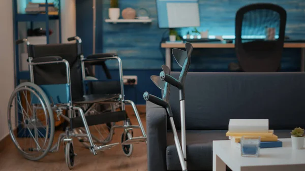 Ingen i vardagsrummet med rullstol och kryckor för att hjälpa till med transport — Stockfoto
