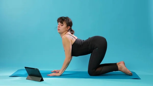 Klidná žena protahuje svaly na podložce na jógu — Stock fotografie