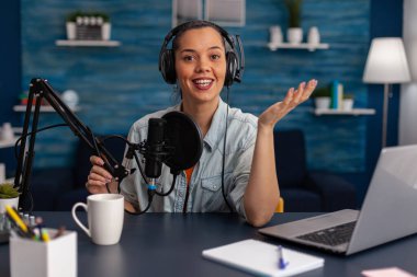 Portrait of woman smiling at camera in home recording studio.