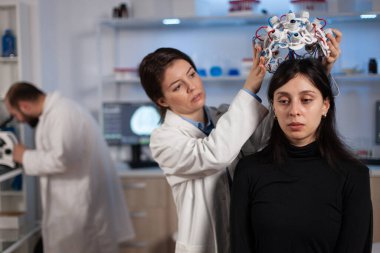 Neurologist doctor woman putting eeg scanner on patient head analyzing brain evolution