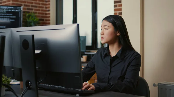 Retrato de programador asiático centrado en escribir código sentado en el escritorio —  Fotos de Stock