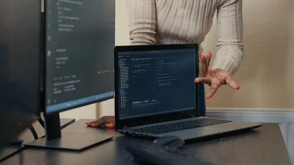 Closeup of laptop running algorithm parsing code on desk in front of programmers doing team work — Foto Stock