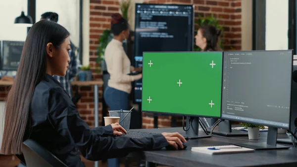 Programador asiático escribiendo código delante de la computadora con pantalla verde croma clave mockup — Foto de Stock