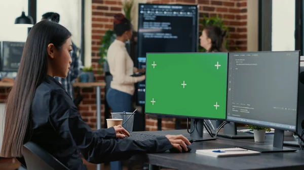Asian programer writing code in front of computer with green screen chroma key mockup — стоковое фото