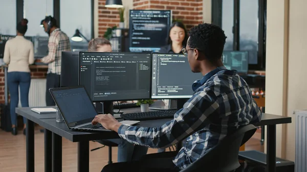 Portrait of programer fixing glasses while typing on laptop smiling satisfied about compiling results sitting at desk — Stok fotoğraf