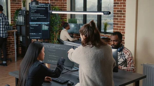 Software programer pointing pencil at source code on computer screen explaining algorithm to coworker — Stok fotoğraf