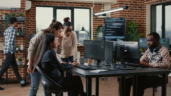 Mixed team of software engineers brainstorming ideas for new code library in front of computer screens — Photo