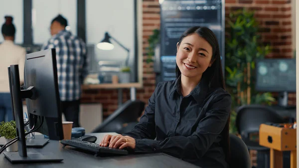 Smiling asian database software developer writing programming code on computer keyboard — Stock Photo, Image