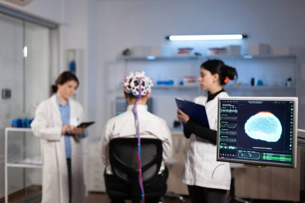 Man patient with eeg headset for brain scan standing in neurological laboratory —  Fotos de Stock
