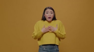 Stüdyoda şaşkın şaşkın bakan koca gözlü bir kadın.