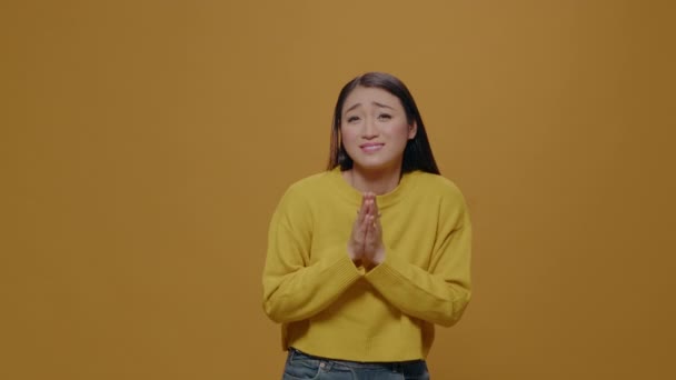 Mujer asiática haciendo gesto de oración con las manos y mendigando — Vídeo de stock