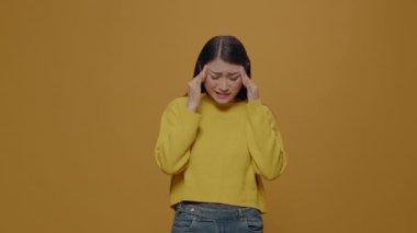 Unhappy adult rubbing temples to cure headache problem