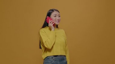 Telefon görüşmesi yapmak için akıllı telefon kullanan Asyalı kadın.