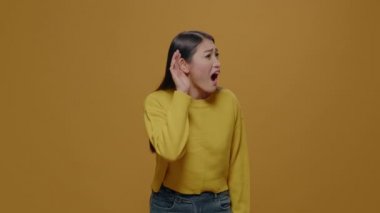 Portrait of woman eavesdropping discussion in studio