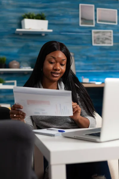 Employee analyzing data charts on files with modern laptop — ストック写真