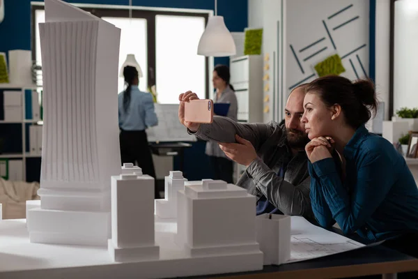 Team of two architect colleagues using smartphone in videocall conference — Photo