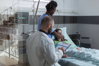 Through the window view of nurse putting oxygen mask on unconscious female patient