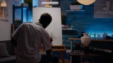 Siyah yaratıcı kişi tuval üzerine vazo tasarımı için kalem kullanıyor.