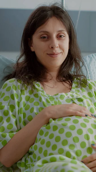 Hamilelik portresi hastane koğuşunda karnını tutuyor. — Stok fotoğraf