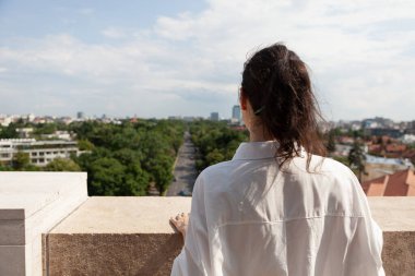 Beyaz kadın kule terasında duruyor yaz tatilinin tadını çıkarıyor.