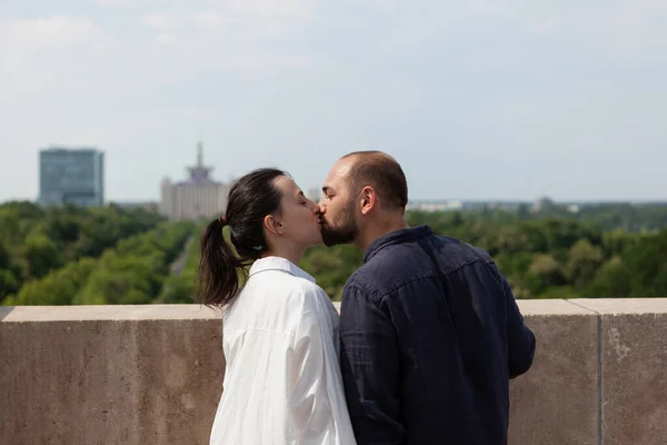 Счастливая супружеская пара целуется на крыше башни — стоковое фото