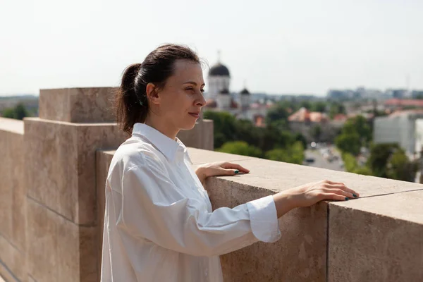 Donna in piedi sul tetto della torre godendo guardando la città metropolitana — Foto Stock