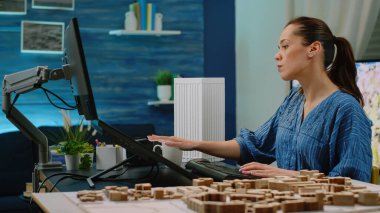 Sanal maketi analiz eden bir kadın mimar olarak çalışıyor.