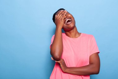 Portrait of smiling joyful african american young woman laughting at camera clipart