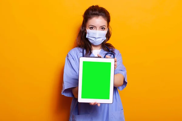 디지털 태블릿에 수직 녹색 화면을 들고 있는 여성 간호사 — 스톡 사진