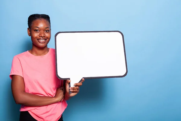 Beyaz sınav pankartı tutarken kameraya gülümseyen Afrikalı Amerikalı genç kadının portresi — Stok fotoğraf