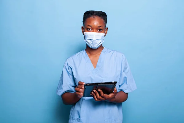 Enfermeira afro-americana usando máscara facial médica para prevenir a infecção pelo coronavírus — Fotografia de Stock