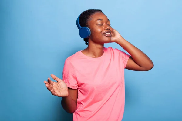 Retrato de adolescente afro-americano com fones de ouvido ouvindo música alegre — Fotografia de Stock