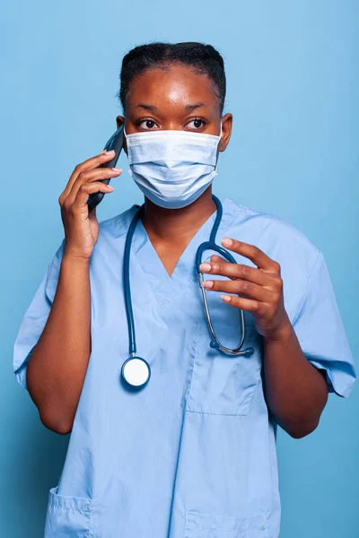 Terapista infermiere afroamericano con maschera protettiva contro il coroanvirus — Foto Stock