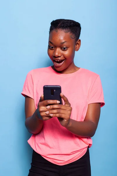 Retrato de mensagens de adolescente afro-americano com amigo usando smartphone — Fotografia de Stock